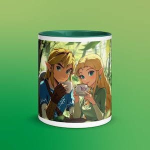 May include: A white ceramic mug with a green rim features a cartoon image of Link and Zelda from the Legend of Zelda video game series. They are both wearing green and blue clothing and holding cups of tea. The background is a green forest.