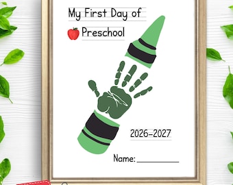 May include: A framed print featuring the text My First Day of Preschool, a red apple icon, and a green handprint shaped like a crayon. The design includes the school year 2026-2027 and a blank line for a name. The frame is gold-colored.
