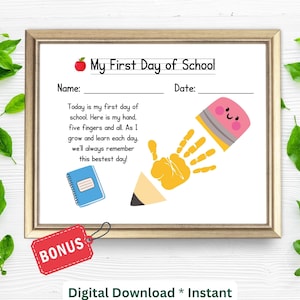 Puede incluir: Un cartel imprimible para el primer día de escuela con una huella de mano amarilla y un lápiz con una goma de borrar rosa. El cartel tiene el texto "My First Day of School" y espacio para el nombre del niño y la fecha.