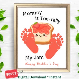 May include: A framed print with a gold border features a cartoon image of a slice of toast with jam and a strawberry, surrounded by orange footprints. The text reads "Mommy is Toe-Tally My Jam Happy Mother's Day."