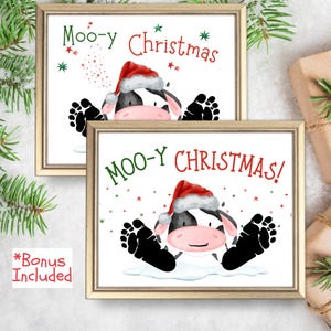 Peut inclure: Deux impressions encadrées avec une vache de dessin animé portant un chapeau de Père Noël et le texte "Moo-y Christmas!" en vert et rouge. La vache est noire et blanche avec des accents roses et des empreintes de sabots noires.