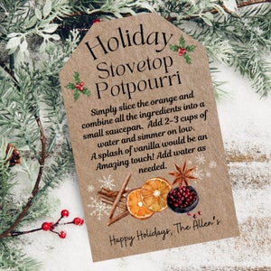 Puede incluir: Una etiqueta de papel marrón con el texto "Holiday Stovetop Potpourri" e instrucciones para hacer un popurrí para la estufa. La etiqueta incluye un gráfico de rodajas de naranja, palitos de canela, anís estrellado y arándanos.