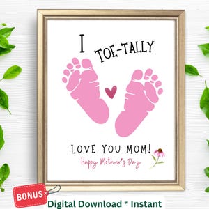 May include: Framed print with the text "I TOE-TALLY LOVE YOU MOM! Happy Mother's Day" featuring pink baby footprints and a heart. A bonus tag is attached to the frame. A digital download is available.
