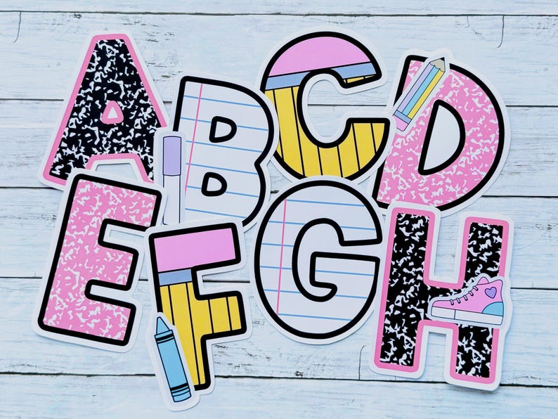 May include: A collection of colorful alphabet stickers, each designed with a unique pattern and school-themed illustrations. The letters A, B, C, D, E, F, G, and H are visible, featuring elements like pencils, notebooks, and a sneaker. The stickers are set against a light blue wooden background.