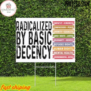 Peut inclure: Un panneau de jardin blanc avec le texte "RADICALIZED BY BASIC DECENCY" en lettres noires en gras. Le panneau énumère également divers sujets de justice sociale tels que "LGBTQ+ RIGHTS * JUSTICE" et "HUMAN RIGHTS". Le panneau est sur un support métallique.