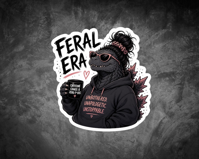 Op de afbeelding: Een sticker met een Godzilla-achtig wezen met een zonnebril en een hoodie. De tekst "FERAL ERA" staat boven het wezen. De hoodie zegt "UNBOTHERED, UNAPOLOGETIC, UNSTOPPABLE." Het wezen houdt een mok vast met "CAFFEINE, CHAOS & ZERO F*CKS."