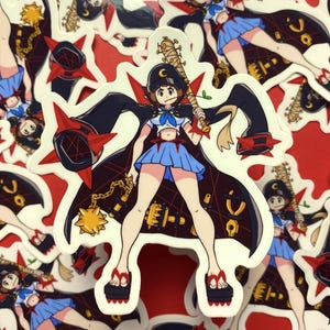 Peut inclure: Un autocollant représentant un personnage de dessin animé avec une cape rouge et noire, tenant une batte de baseball. Le personnage porte une jupe bleue, une chemise blanche et des bottes noires. L'autocollant est sur un fond rouge.