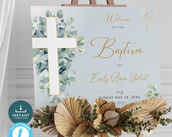 May include: A light blue welcome sign with a white cross and gold lettering. The sign says "Welcome to the Baptism of Emily Anna Juliet, Sunday Nov 16, 20XX". The sign is decorated with watercolor eucalyptus leaves.
