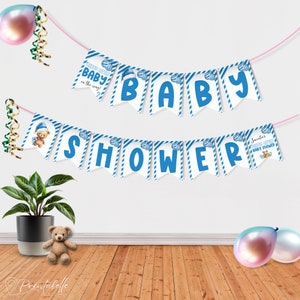 Op de afbeelding: Een babyshowerbanner met blauwe en witte vlaggetjes met de tekst "BABY SHOWER". De banner bevat vlaggetjes met teddybeerillustraties en de zinnen "Heart little baby in the way!" en "Juanto's little baby shower."