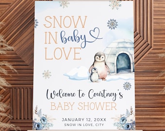 May include: A baby shower sign on an easel with a winter theme. The sign features the text "SNOW IN baby LOVE" and "Welcome to Courtney's BABY SHOWER". It includes illustrations of penguins, an igloo, and snowflakes. The date is January 12, 20XX.