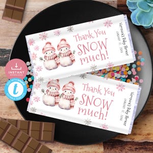 Könnte beinhalten: Zwei bedruckbare Schokoladenriegel-Verpackungen mit einem Winterthema mit zwei Schneemännern in rosa Mützen und Schals. Die Verpackungen sagen "Vielen Dank für den Schnee!" und enthalten den Text "Veronicas Babyparty" und das Datum "12. Januar 20XX".