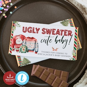 Könnte beinhalten: Ein druckbarer Schokoladenriegel-Wrapper mit Weihnachtsmotiv. Der Wrapper hat einen weißen Hintergrund mit roten und grünen Illustrationen von hässlichen Pullovern und dem Text "Ugly Sweater, cute baby!" und "Danke, dass du zur Babyparty von Mike & Jackie gekommen bist".