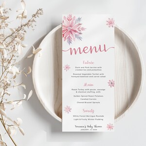 Może przedstawiać: Różowe i białe menu w zimowym stylu na baby shower. Menu zawiera wzór płatka śniegu i zawiera listę przystawek, dania głównego i deserów. Tekst brzmi: "menu", "Przystawka", "Terrina z kaczki i wieprzowiny z żurawiną i pistacjami", "Tarteletka z pieczonymi warzywami z miodową burakami i marchewką", "Danie główne", "Pieczony indyk z orzechami pekan, kiełbasą i nadzieniem z kasztanów, z: Złotymi przyprawionymi ziemniakami Karmelizowanymi marchewkami Opiekanymi brukselkami", "Desery", "Biała laska meringowa", "Lekki i owocowy zimowy pudding", "Baby Shower Veroniki", "STYCZEŃ, 12 20XX".