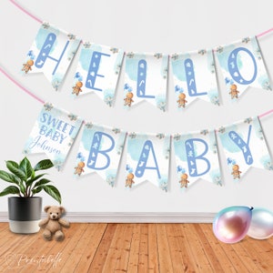 May include: A blue and white baby shower banner with the words "Hello Sweet Baby Johnson" and gingerbread men illustrations.
