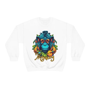 May include: White sweatshirt featuring a colourful illustration of a monkey's face surrounded by leaves and fruit. The text "Monkey" is written in yellow below the image.