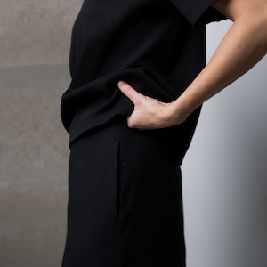 May include: A black short-sleeved t-shirt and a black skirt.