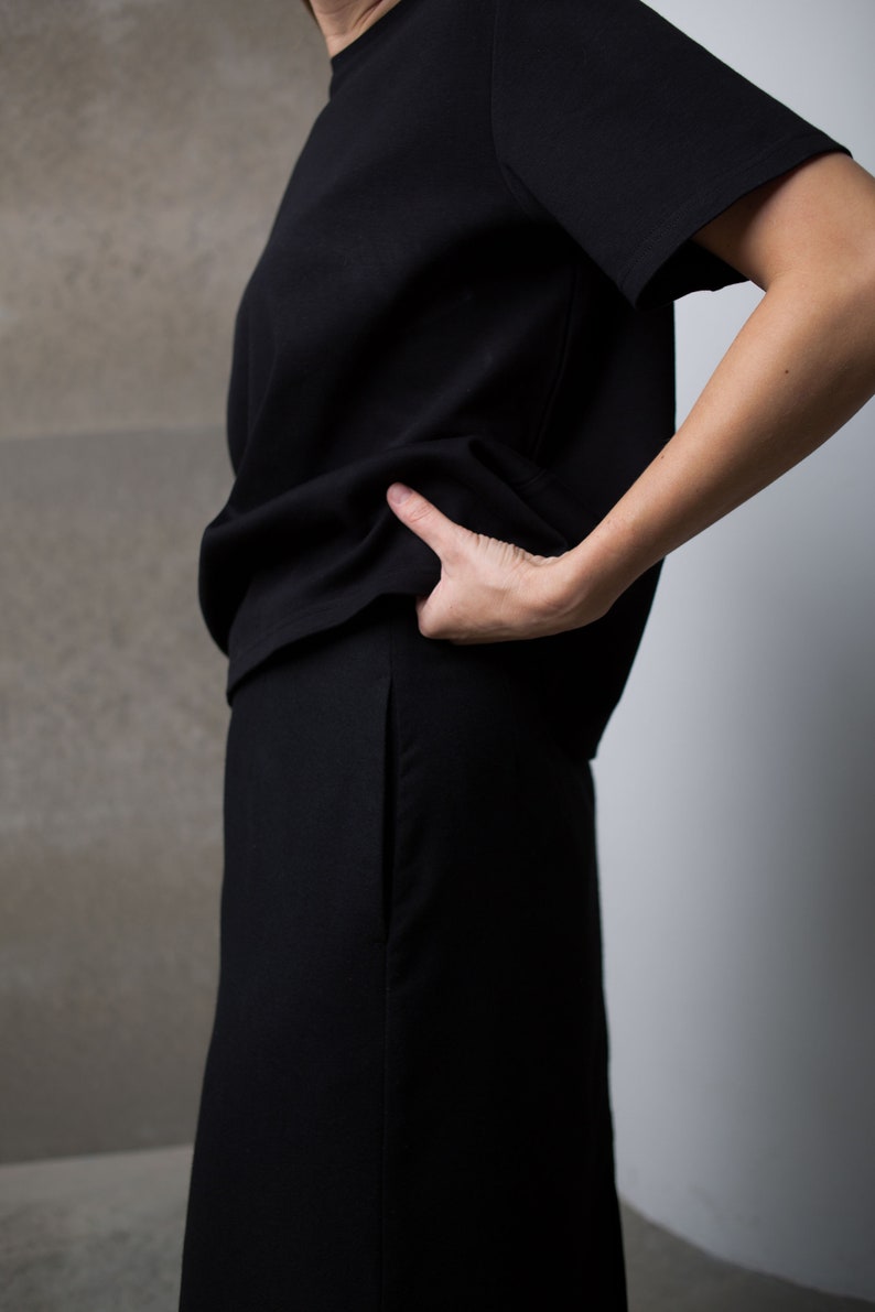 May include: A black short-sleeved t-shirt and a black skirt.