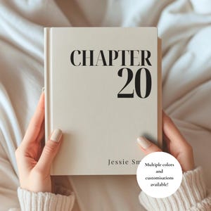 Op de afbeelding: Een crèmekleurig hardcover boek met de zwarte tekst CHAPTER 20 in een groot schreeflettertype aan de bovenkant en de naam Jessie Sm in een kleiner lettertype aan de onderkant. Het boek heeft een gladde, matte afwerking en een strak ontwerp.