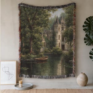 Puede incluir: Tapiz tejido que presenta un paisaje sereno con un castillo en un lago, rodeado de exuberantes árboles verdes. La obra de arte incluye un pequeño bote en el agua y una representación detallada de la arquitectura del castillo. El tapiz tiene un borde con flecos.