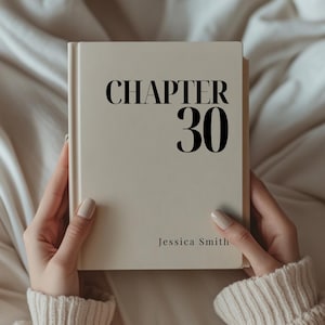May include: A hardcover book with a cream-colored cover. The title "CHAPTER 30" is printed in bold black letters. The author's name, Jessica Smith, is printed below the title. The book is held by a person wearing a cream-colored sweater.