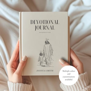 Può includere: Un diario devozionale con copertina rigida color crema e testo nero che recita DEVOTIONAL JOURNAL DAUGHTER OF GOD. La copertina presenta un disegno a linee nere di una persona che cammina con Gesù, etichettato me e Jesus, con il nome JESSICA SMITH.