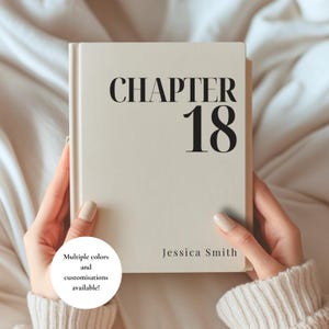 May include: A rectangular, off-white hardcover book featuring the black text "CHAPTER 18" in a large, bold serif font at the top and the name "Jessica Smith" in a smaller, elegant serif font at the bottom right corner of the front cover.
