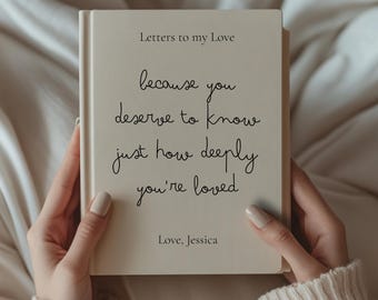May include: A cream-colored book titled "Letters to my Love" held by a person. The cover features handwritten text that reads "because you deserve to know just how deeply you're loved." The book is signed "Love, Jessica."