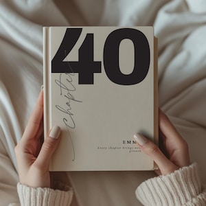 May include: A beige book with the number "40" in large black font on the cover. The word "Chapter" is written in cursive. The text "Every chapter brings new growth" is also on the cover.