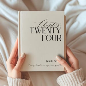 Könnte beinhalten: Ein cremefarbenes Buch mit schwarzem Text auf dem Einband. Der Text lautet Chapter TWENTY FOUR, Jessie Sm und Every chapter brings new growth. Das Buch hat eine glatte, matte Oberfläche und einen vertikalen Buchrücken auf der linken Seite.