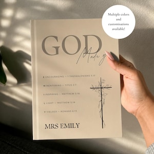 Op de afbeelding: Een beige hardcover boek met de tekst GOD Made y, gevolgd door een acrostichon voor EMILY met bijbelverwijzingen en een bloemrijke kruisillustratie. Onderaan de kaft staat de naam MRS EMILY in een vetgedrukt, zwart, schreefloos lettertype.