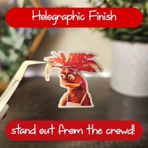 Może przedstawiać: Holograficzna naklejka przedstawiająca kresk&oacute;wkowego kurczaka z czerwonym irokezem i tekstem "stand out from the crowd!"