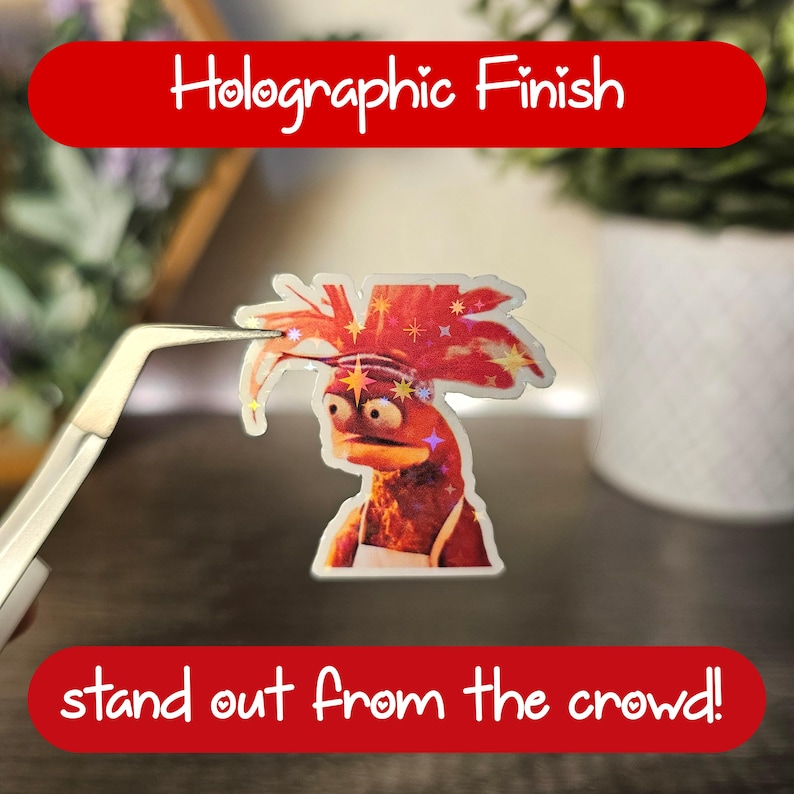 Może przedstawiać: Holograficzna naklejka przedstawiająca kresk&oacute;wkowego kurczaka z czerwonym irokezem i tekstem "stand out from the crowd!"