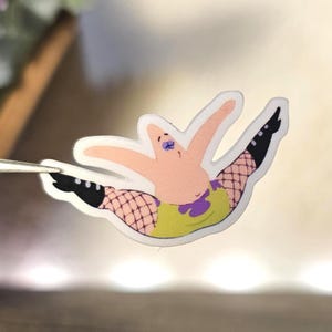 May include: A die-cut sticker featuring a cartoon starfish character with a light pink body, wearing a lime green leotard with a purple accent, black fishnet stockings, and black boots, posed with legs spread wide in a high-energy dance move.