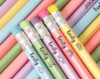 May include: A selection of pastel-coloured pencils, each with a name printed on the side. The pencils are in shades of pink, yellow, blue, green, and purple. The pencils have silver metal ferrules and pink, blue, and yellow erasers.
