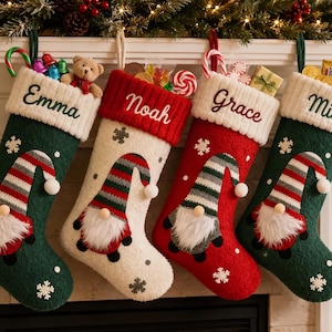 May include: Four Christmas stockings in green, white, and red featuring embroidered names Emma, Noah, Grace, and Milo. Each stocking has a textured cuff, a gnome applique with a striped hat and white beard, and small snowflake accents throughout.