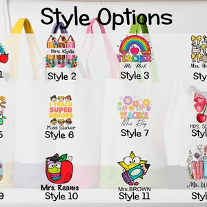May include: Twelve white tote bags are displayed, each featuring a unique design with text and illustrations. Designs include rainbows, pencils, and apples. Each bag has a different style number and handle colour.