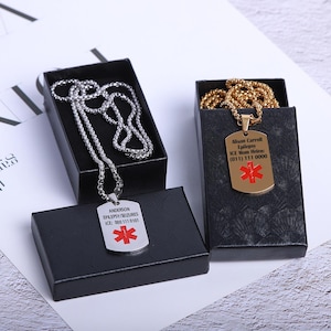 May include: Two silver necklaces with medical alert tags. The tag on the left reads "ANDERSON EPILEPSY SEIZURES ICE: 0001110101" with a red star of life symbol. The tag on the right reads "Alison Carroll Epilepsy ICE: Mom Home (011) 111 0000" with a red star of life symbol.
