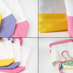 May include: White canvas tote bags with colour-blocked bottoms in yellow, lavender, and pink. The bags have matching coloured handles and are shown empty and filled with books. The bags are a simple, stylish design.