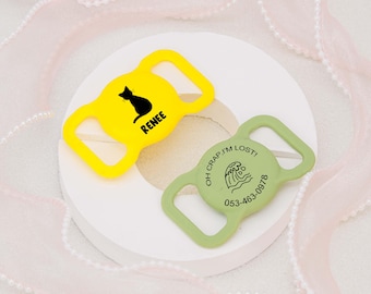 May include: Two yellow and green plastic dog collar tags. The yellow tag has a black silhouette of a cat and the text "Renee". The green tag has a wave graphic and the text "Oh crap! I'm lost! 053-463-0978".