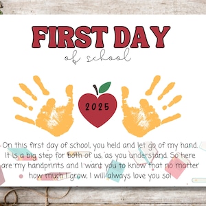 May include: A white print with the text "FIRST DAY of school" in red and black. It features orange handprints and a red apple with "2025" inside. The print includes a heartfelt message about the first day of school.