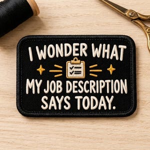 May include: A rectangular black embroidered patch featuring white text that reads I WONDER WHAT MY JOB DESCRIPTION SAYS TODAY. The design includes a central gold clipboard icon with two checkmarks, flanked by two gold stars and horizontal lines.