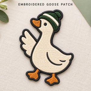 May include: An embroidered goose patch featuring a cream-coloured goose with orange feet and beak, wearing a dark green knit cap with a white stripe. The patch has a black border and the text EMBROIDERED GOOSE PATCH is printed above it.
