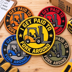 May include: Five circular embroidered patches featuring a forklift illustration in the center. Each patch displays the text I GET PAID TO FORK AROUND in bold lettering. The patches come in yellow, orange, red, blue, and olive green color variations.