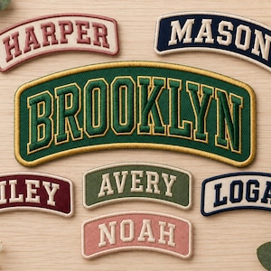 Könnte beinhalten: Eine Sammlung von sieben gebogenen gestickten Aufnähern mit Namen und dem Wort BROOKLYN in Varsity-Schrift. Die Aufnäher sind in verschiedenen Farben erhältlich, darunter Dunkelgrün, Marineblau, Kastanienbraun, Olivgrün und Altrosa mit weißem Text.
