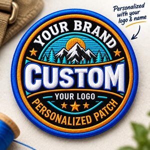May include: A circular embroidered patch featuring a mountain landscape with a sun, pine trees, and stars. The text reads YOUR BRAND, CUSTOM, YOUR LOGO, and PERSONALIZED PATCH. The design uses black, white, blue, and orange thread colours.