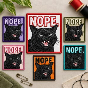 Puede incluir: Una colección de seis parches rectangulares bordados que muestran un gato negro con la boca abierta y el texto NOPE. Los parches vienen en varios colores de fondo, incluyendo morado, blanco, beige, rosa, naranja y azul verdoso.