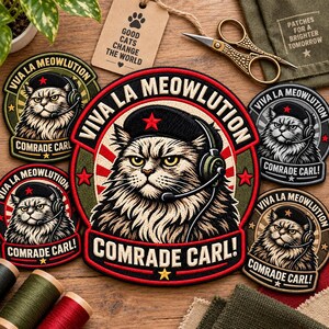 Könnte beinhalten: Runde gestickte Aufnäher mit einer flauschigen Katze, die ein schwarzes Barett mit rotem Stern und ein Headset trägt. Der Text lautet VIVA LA MEOWLUTION und COMRADE CARL! Das Design zeigt rote Sonnenstrahlen und Sterne auf dunkelgrünem und schwarzem Grund.
