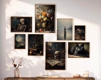 May include: A gallery wall with nine framed prints featuring a variety of dark and moody imagery, including a skull, a snake, a spider, a cat, and a woman in a long dress. The prints are arranged in a grid pattern on a white wall.