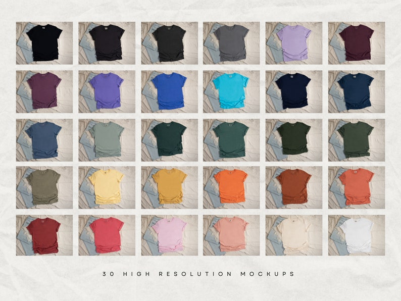 May include: Thirty high-resolution mockups of t-shirts in various colors, including black, purple, blue, green, yellow, orange, red, pink, and white. The shirts are laid out on a textured surface with a denim background.