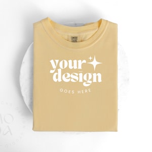 Boter Comfort Kleuren 1717 Mockup | Opgevouwen T-shirt Mock Up | Comfortkleurenmodel | Flatlay-mockup | Unisex-gevouwen mockups